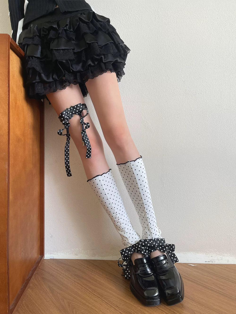 White polka-dot sock covers with a black clip ring and layered bows.