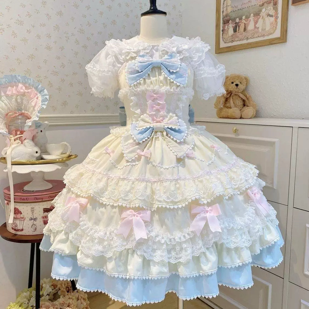Pastel pink JSK dress with tiered ruffles and large bows displayed on a mannequin.