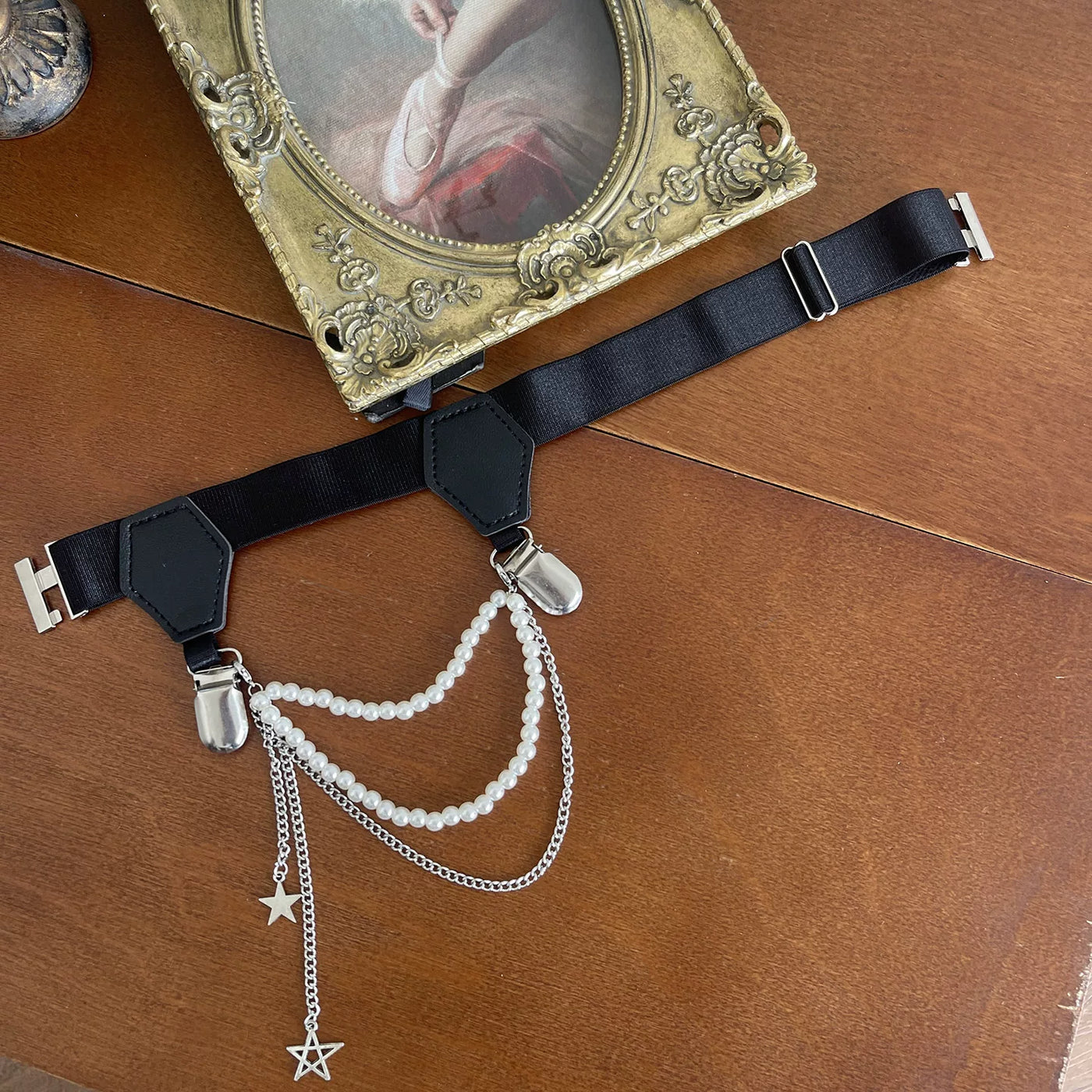 White thigh garter with pearl chains and a silver hanging chain worn over lace stockings