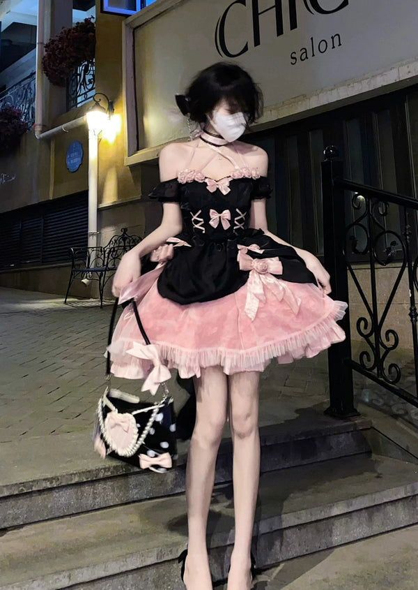 Black and pink off-shoulder Lolita dress with rose appliqués, corset lacing, and layered ruffled skirt, styled with a white choker and black polka dot handbag.