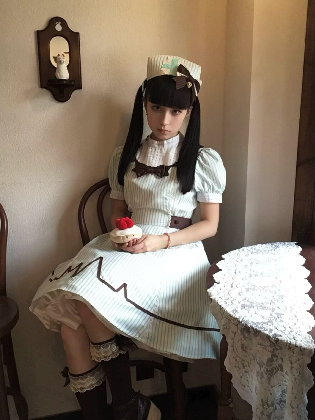 Mint-and-white striped Lolita OP dress with nurse-style collar and dark bow.