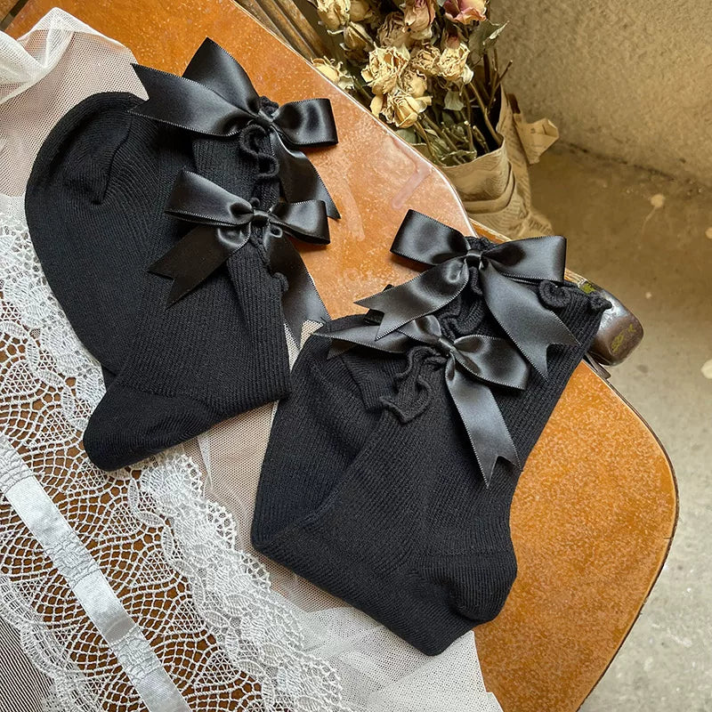 Black and white scrunch socks with bow details styled with black platform Mary Jane shoes.