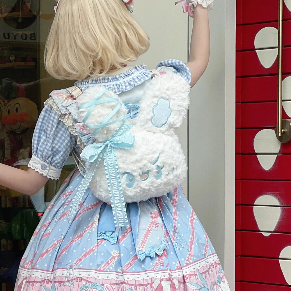 White plush rabbit backpack with pale-blue ribbons and trim styled with a blue Lolita dress