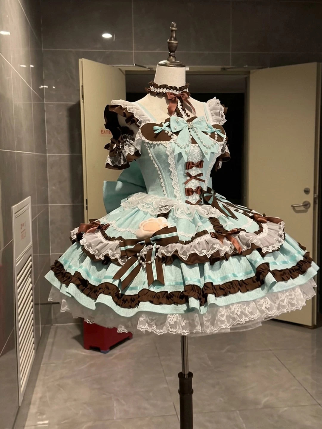 Creamy mint-and-brown JSK dress set with lace ruffles and ribbon bows on a mannequin
