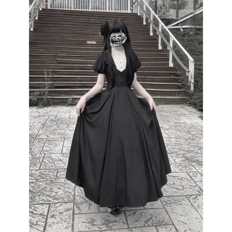 Model wearing a black vintage Gothic one-piece dress with a white inset front and long full skirt