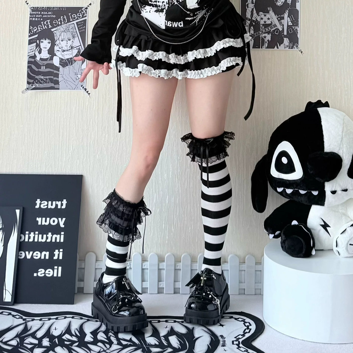 Black-and-white striped over-the-knee socks with gathered cuffs styled with a black outfit