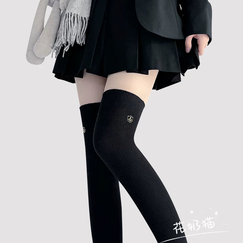 Black vertical ribbed over-the-knee Lolita sock with gold shield emblem