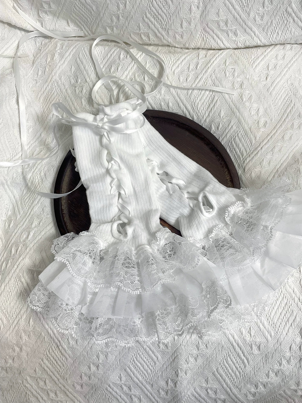 White lace sleeve covers shown flat and worn with ribbon ties and layered ruffles.