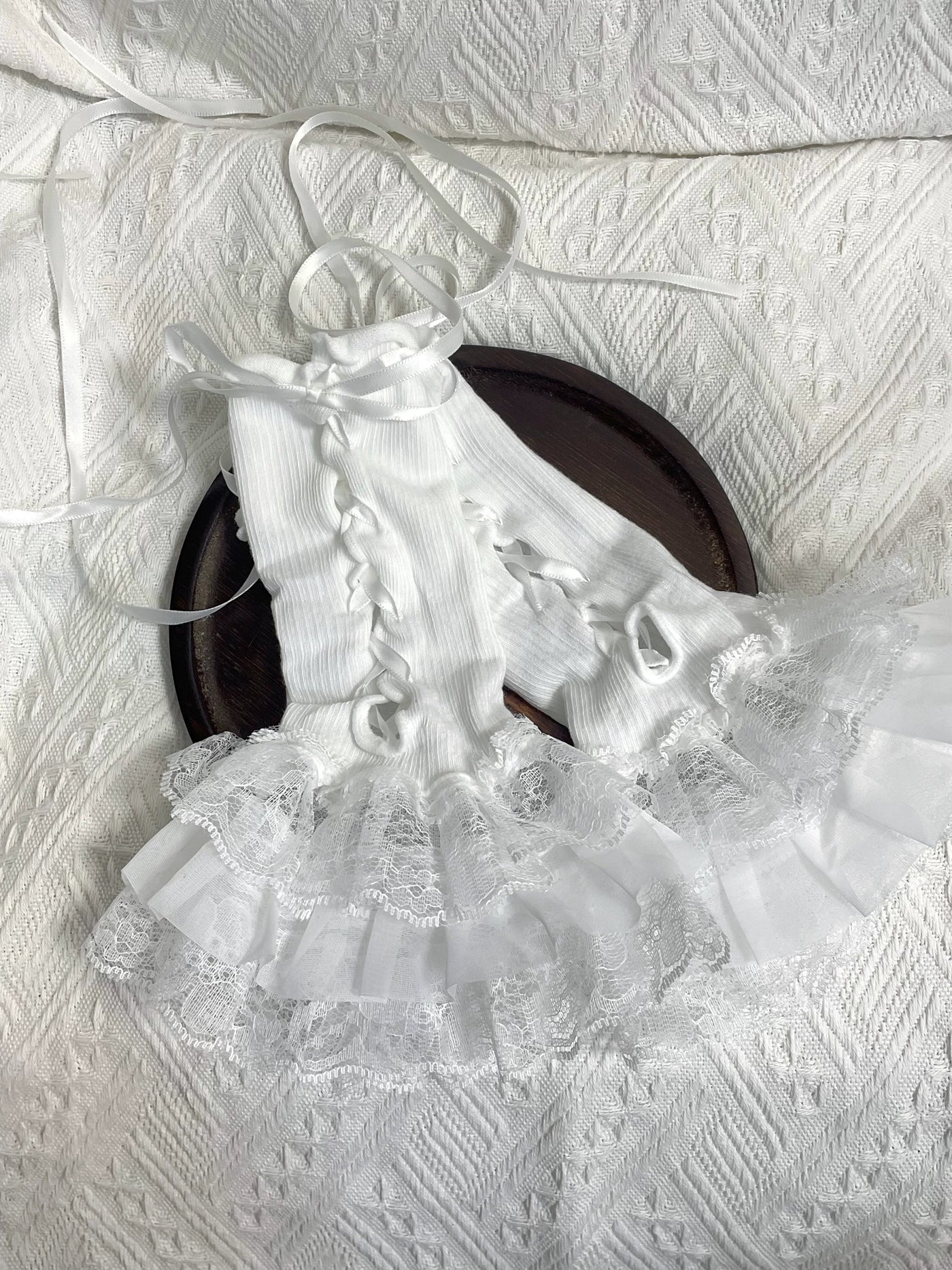 White lace sleeve covers shown flat and worn with ribbon ties and layered ruffles.