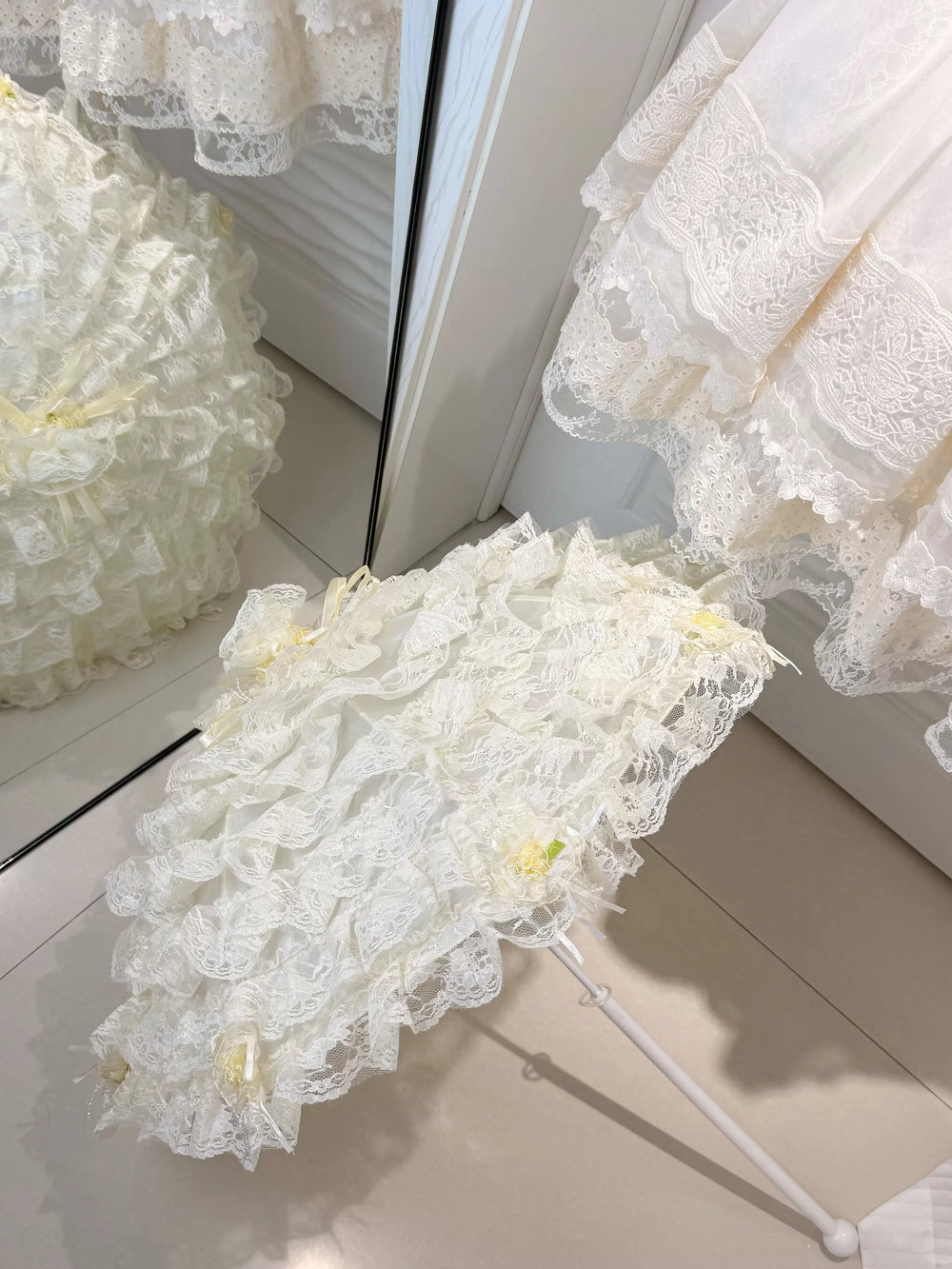 Close view of layered lace and bow detailing on a decorative umbrella.