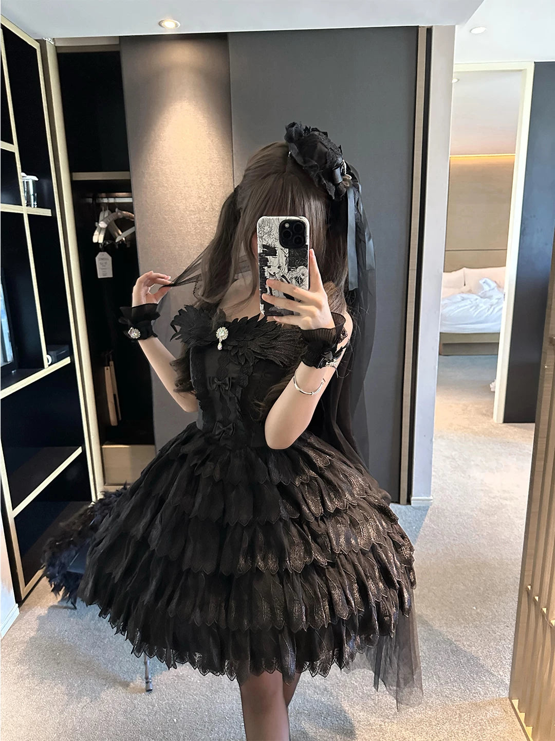 Black JSK dress with layered feather-shaped trim and lace detailing shown in a mirror.