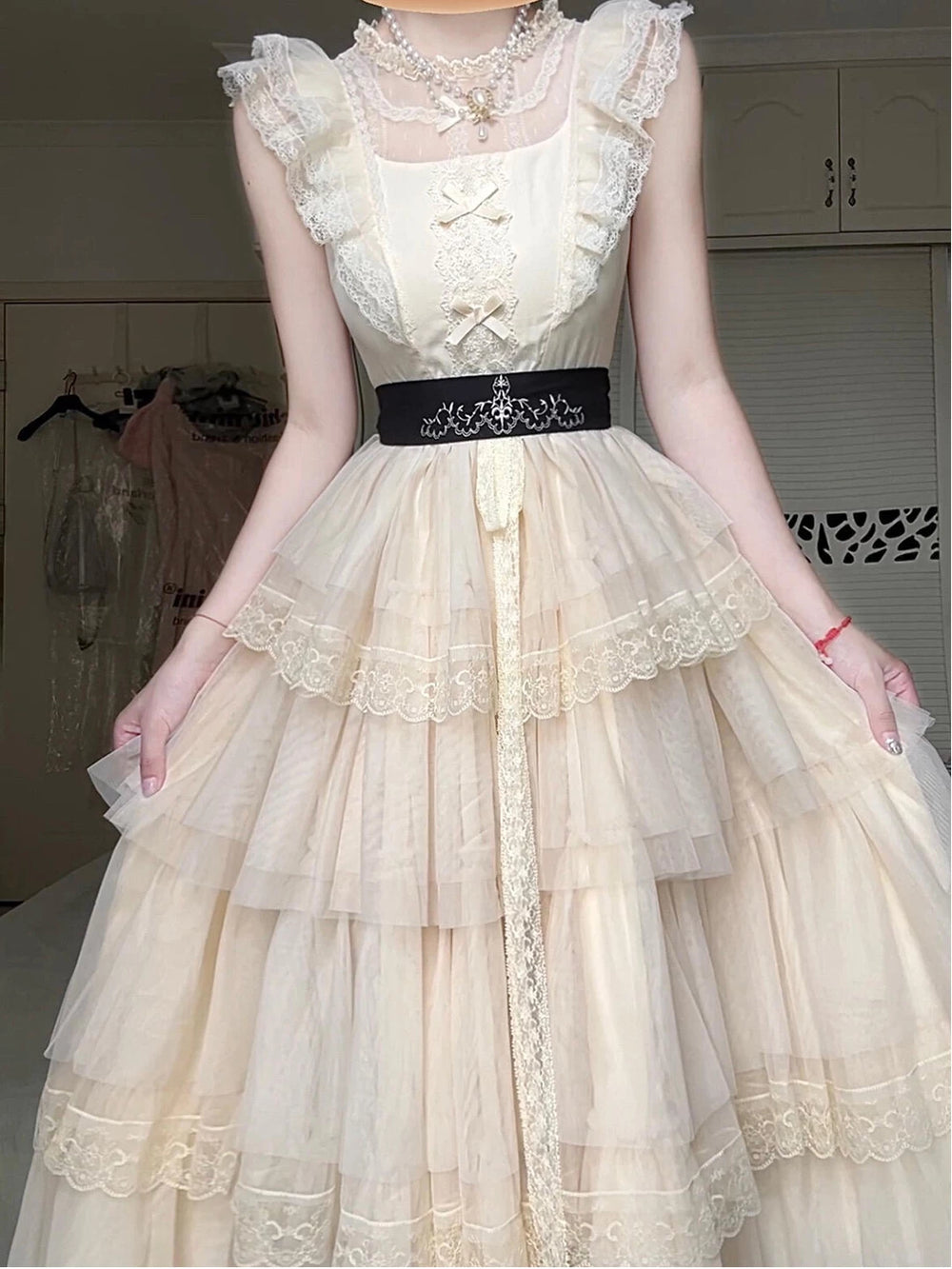 Ivory tiered OP dress with ruffled cap sleeves, scalloped lace edging and a waist belt.