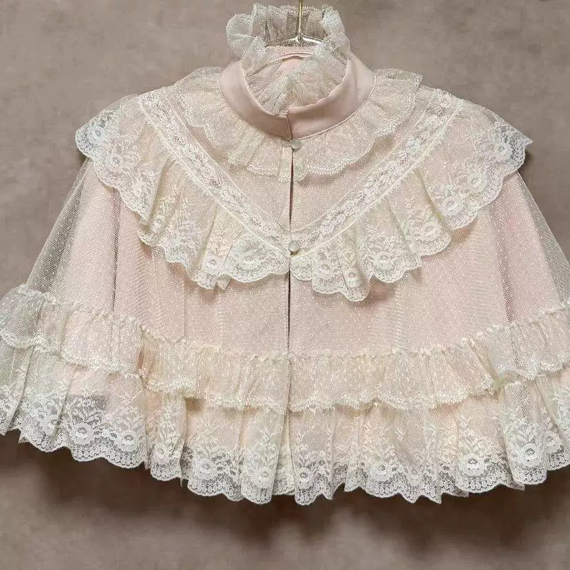 Pink lace cape with layered ruffles, raised collar and front buttons