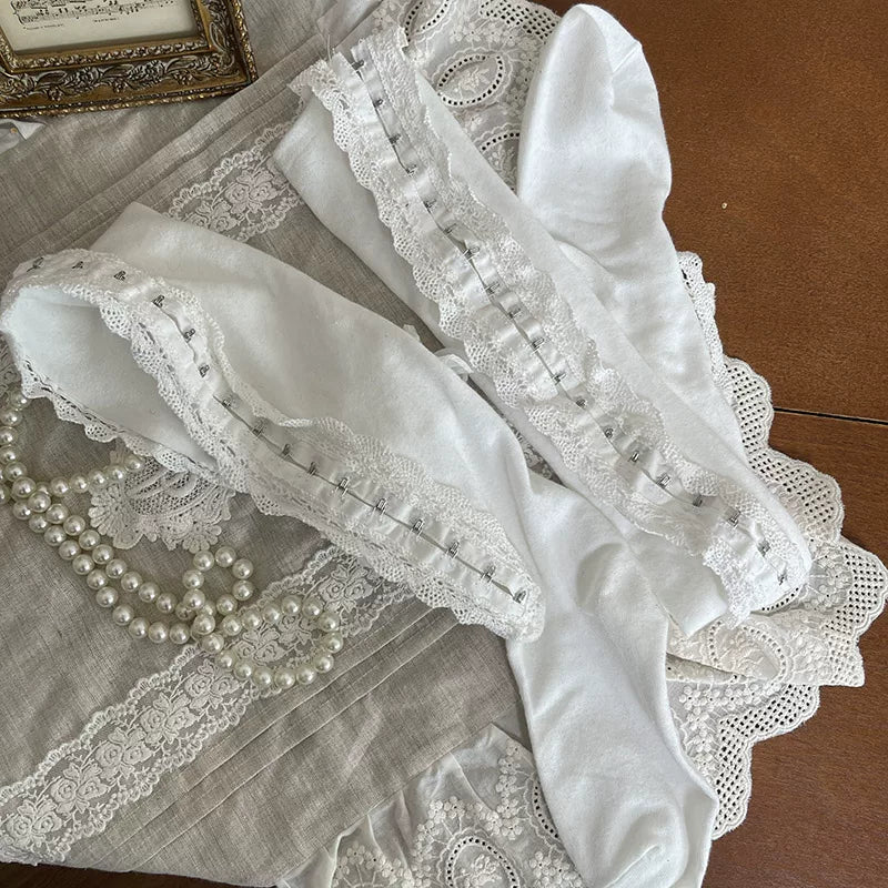 White ribbed tights layered with lace and button-trim socks