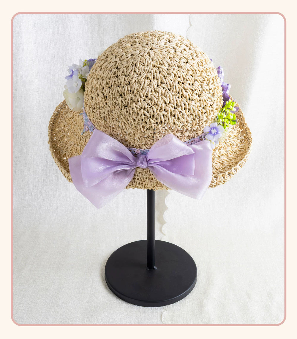 Textured woven straw hat with lavender bow and floral trim displayed on a black stand.
