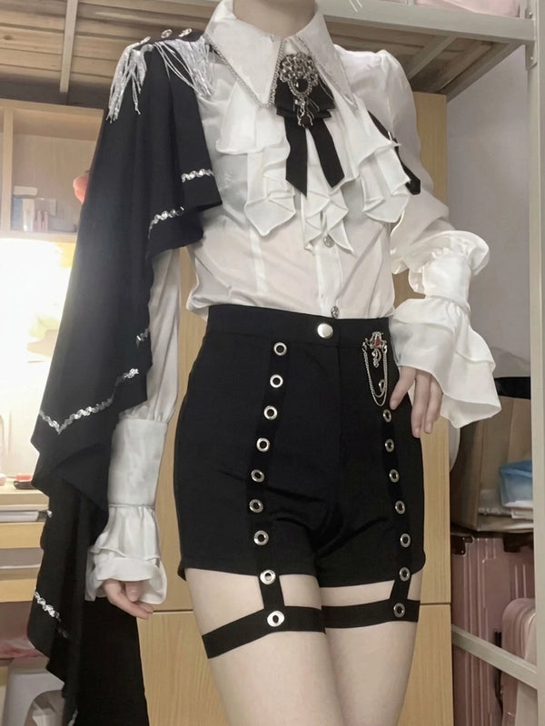 White ruffled blouse with black tasselled shoulder shawl and black eyelet shorts
