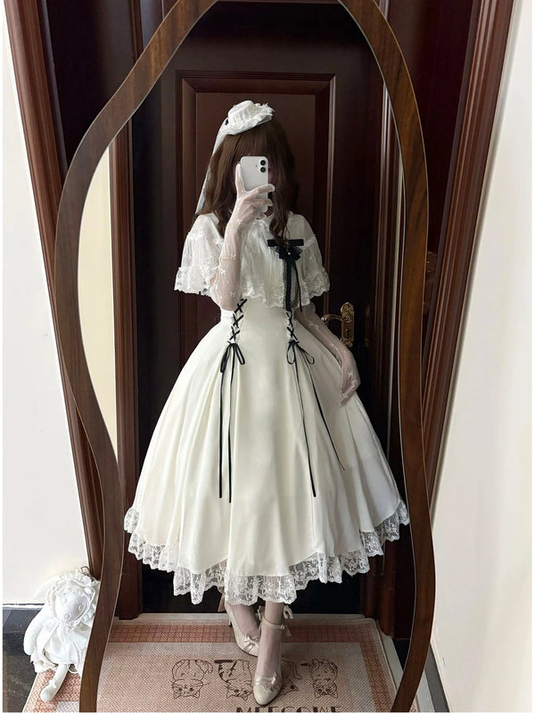 Creamy white waist-cinched one-piece dress with lace trim and black ribbon accents.