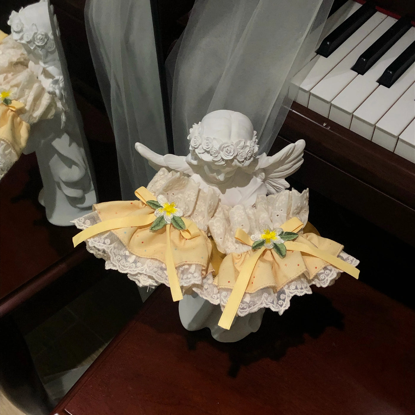 Back view of a lemon-yellow OP dress with white lace edging and a large bow.