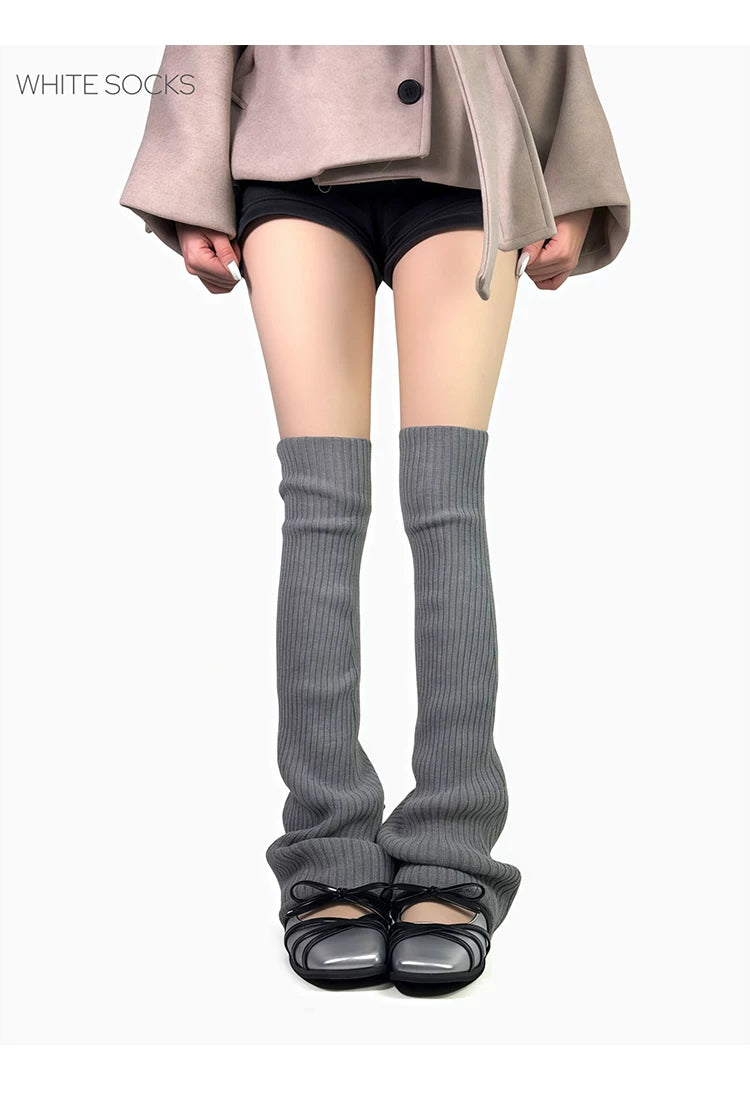 Grey ribbed calf sock leg warmers worn with black shoes on a model
