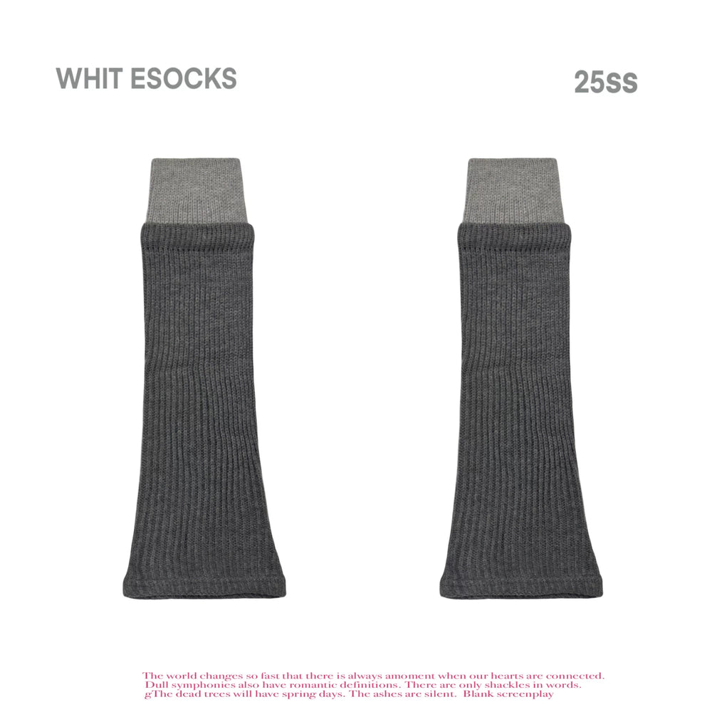 Color-block ribbed mid-calf leg warmers in gray and cream tones styled over neutral shoes.