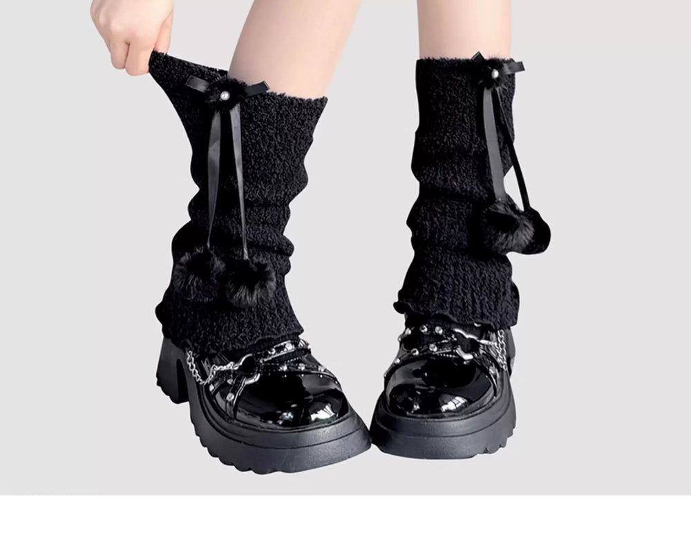Black and white slouchy mid-calf socks with bows, pom-poms and ruffle trim.