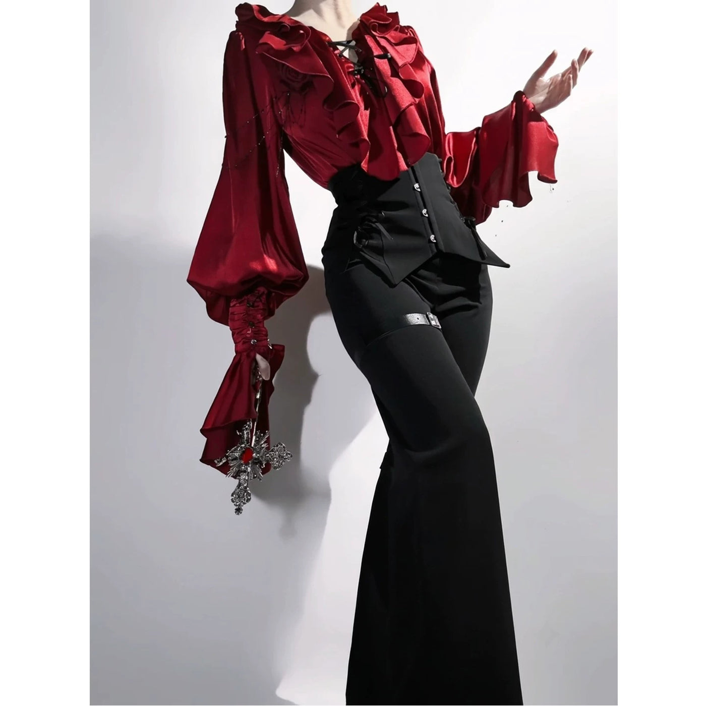Red blouse with voluminous bishop sleeves and black corset-style trousers, detail view