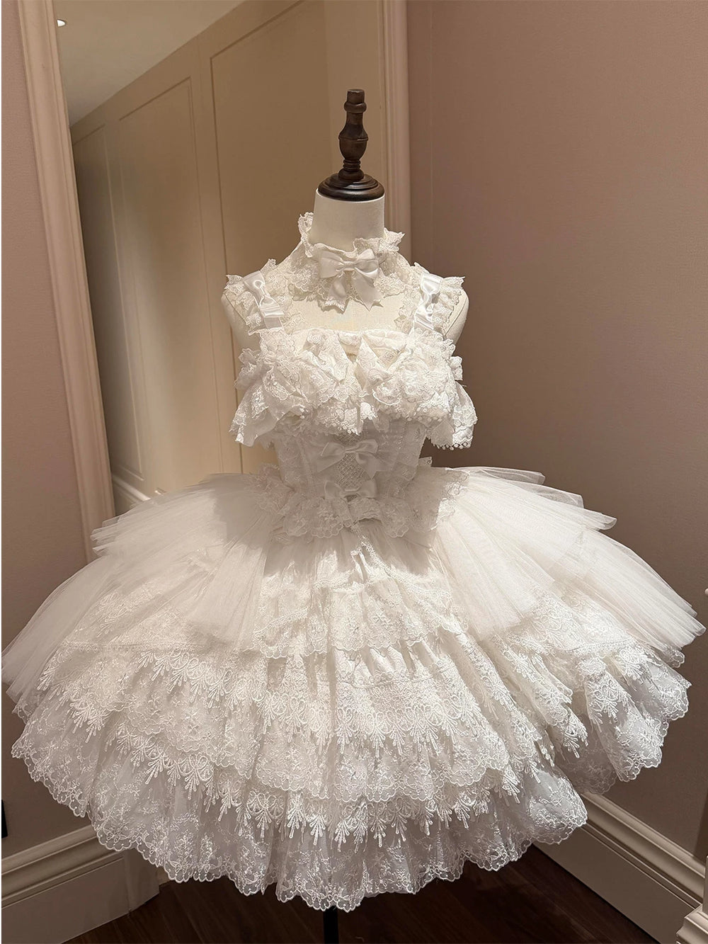 White ballet-inspired JSK dress set with lace ruffles and long train on a mannequin