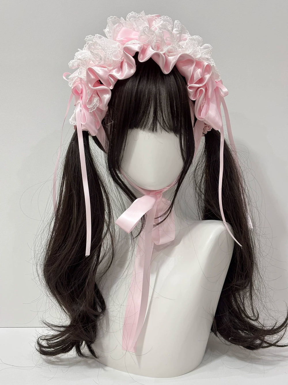 Cat Tart ballet-style satin bow headband with lace ruffles and long trailing ribbons, shown in white and pink on a mannequin.