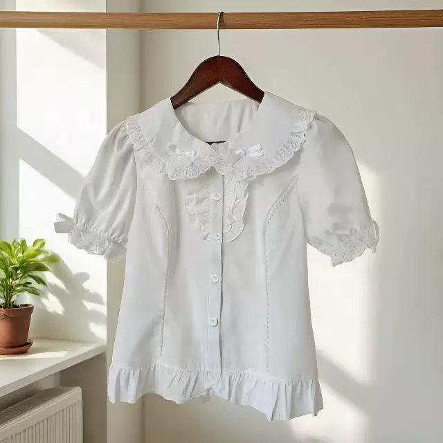 White short-sleeve blouse with a lace collar, front buttons and ruffled hem on a wooden hanger