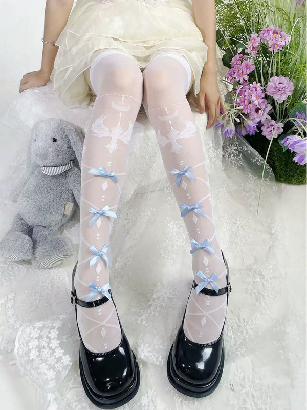 White sheer over-the-knee stockings with pale blue bows and white cross motifs styled with black shoes.