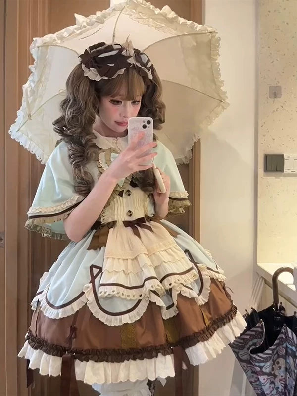 Model wearing a mint and chocolate JSK set with cape and inner layer.