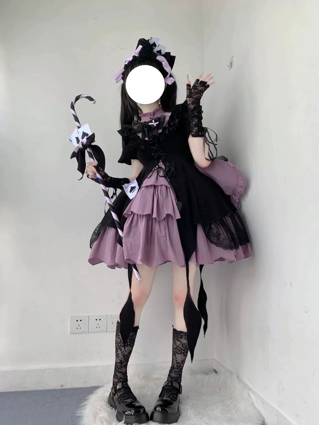 Black-purple ruffled one-piece dress with oversized back bow styled on a model