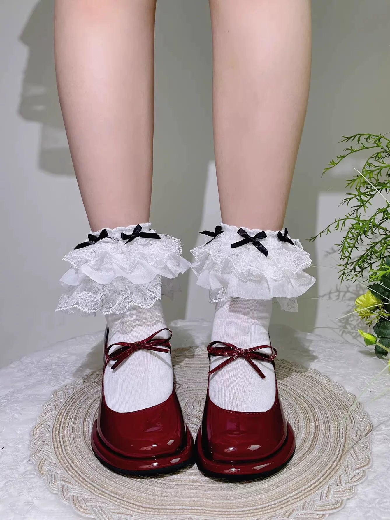 Fantasy Doll white mid-calf socks with layered lace ruffles and black bows styled with red Mary Jane shoes.