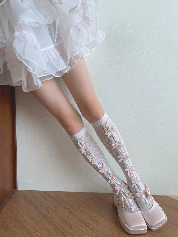 White openwork lace socks with pink bows styled with blush platform shoes.