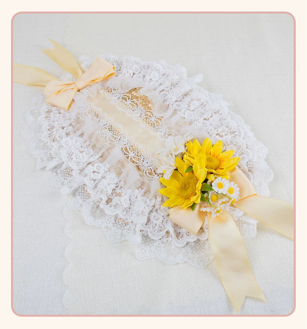 Lace flat straw hat with a large yellow bow and floral embellishment.