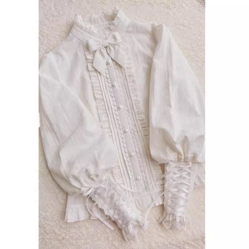 White jacquard blouse with leg-of-mutton sleeves and ruffled lace trim laid flat.