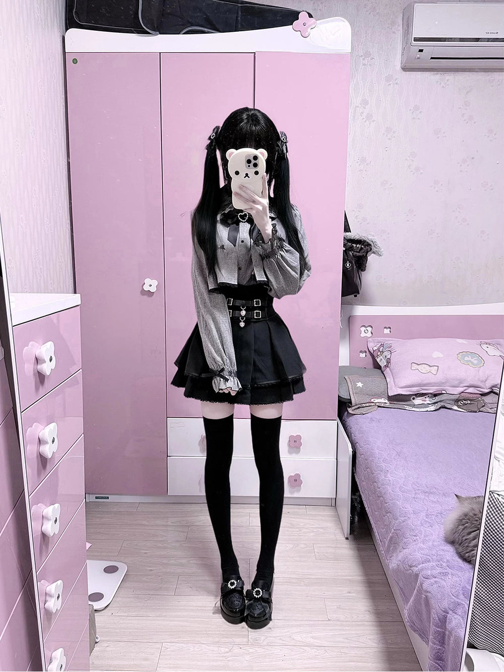 Grey cape-style top and black high-waisted skirt set in mirror photos