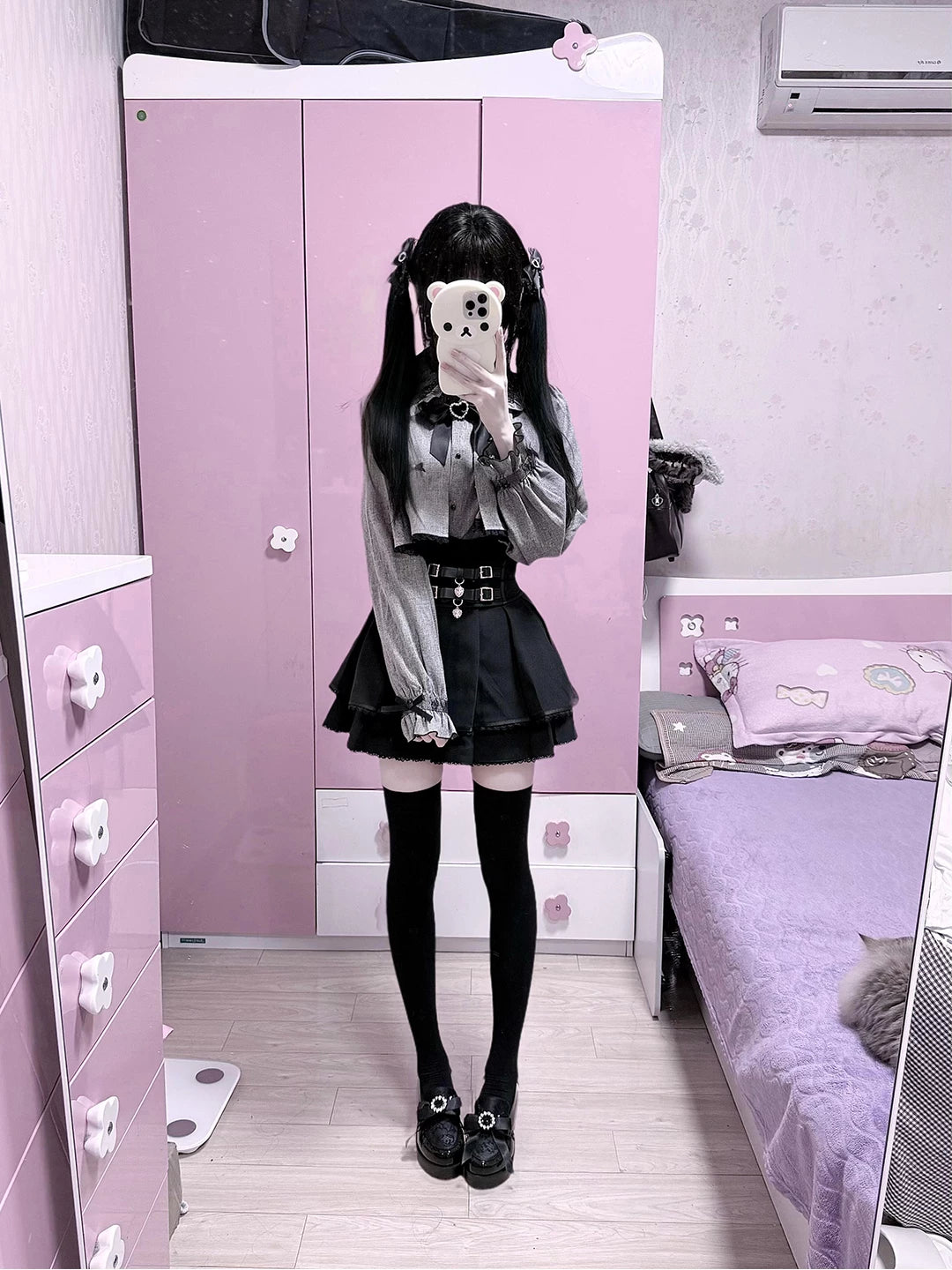 Grey cape-style top and black high-waisted skirt set in mirror photos