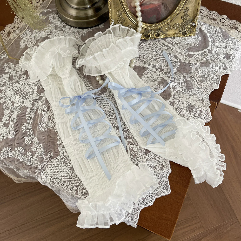 White lace-ruffled long arm sleeves with pale blue tie straps laid flat