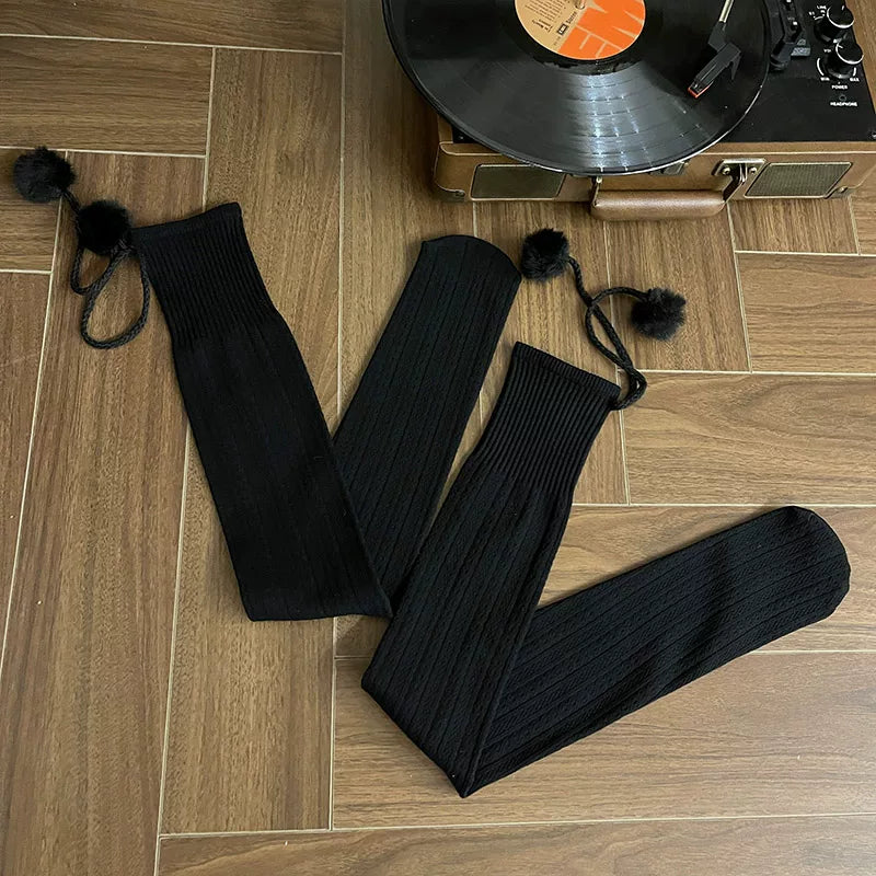 Dark gray cable-knit over-the-knee socks with pom-pom ties