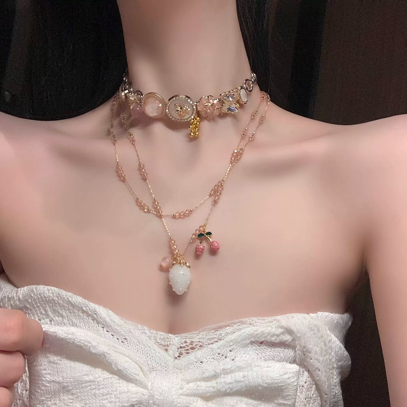 Independent Brand white-jade strawberry and cherry layered necklace shown on a model torso.