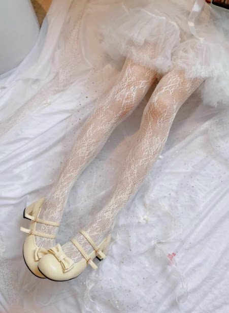 Floral mesh tights in a cream-yellow colourway shown with cream shoes.