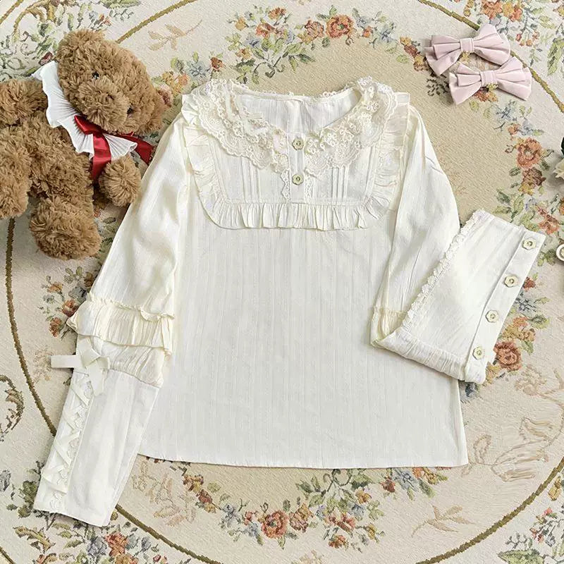 Sweetheart Dream Machine white cotton blouse with lace collar, gathered sleeves and ruffled cuffs, shown in a flat lay.