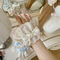 A pair of beige bow cuffs