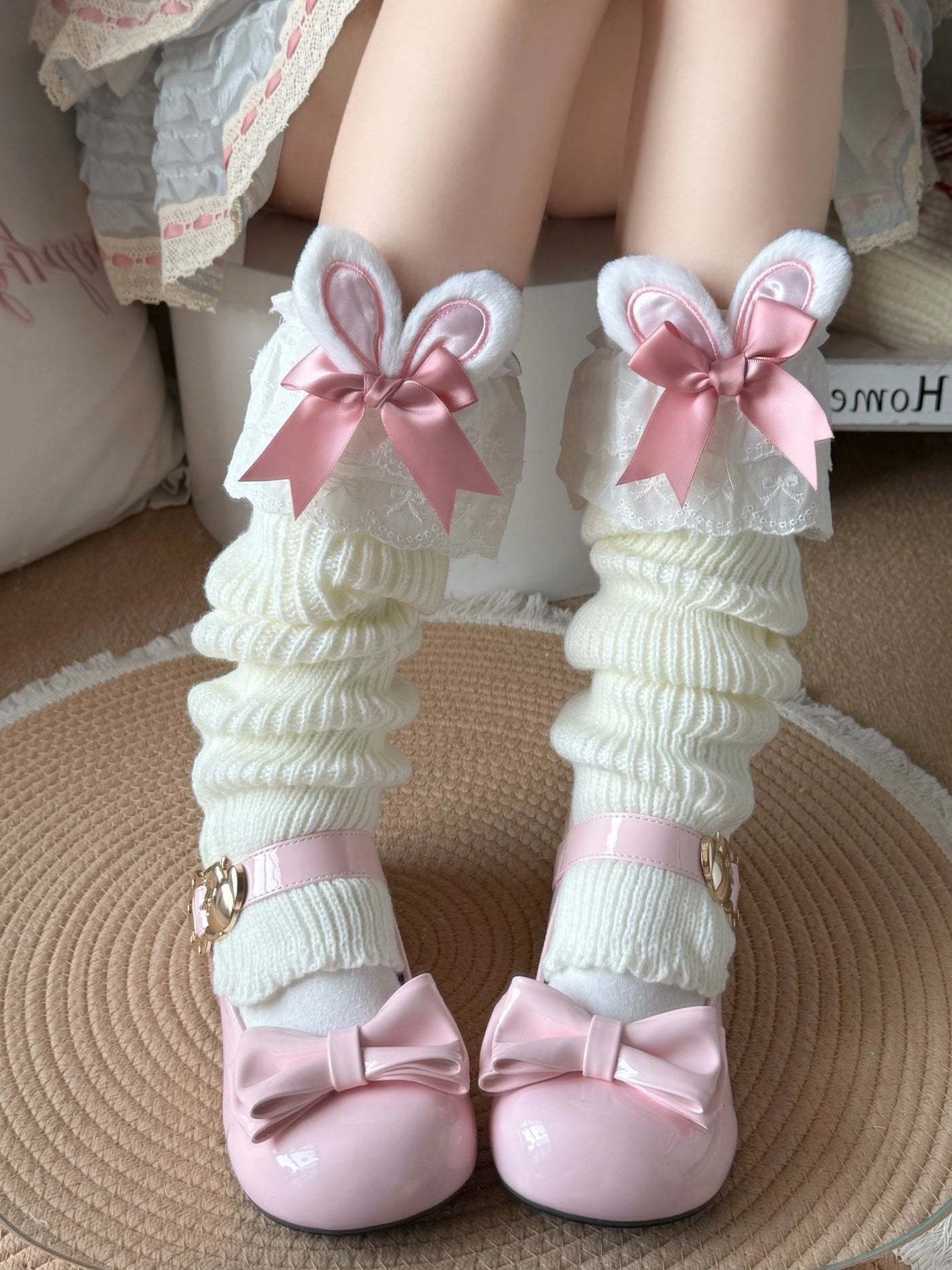 White ruched stirrup leg warmers with bunny ears, lace, and pink bows.