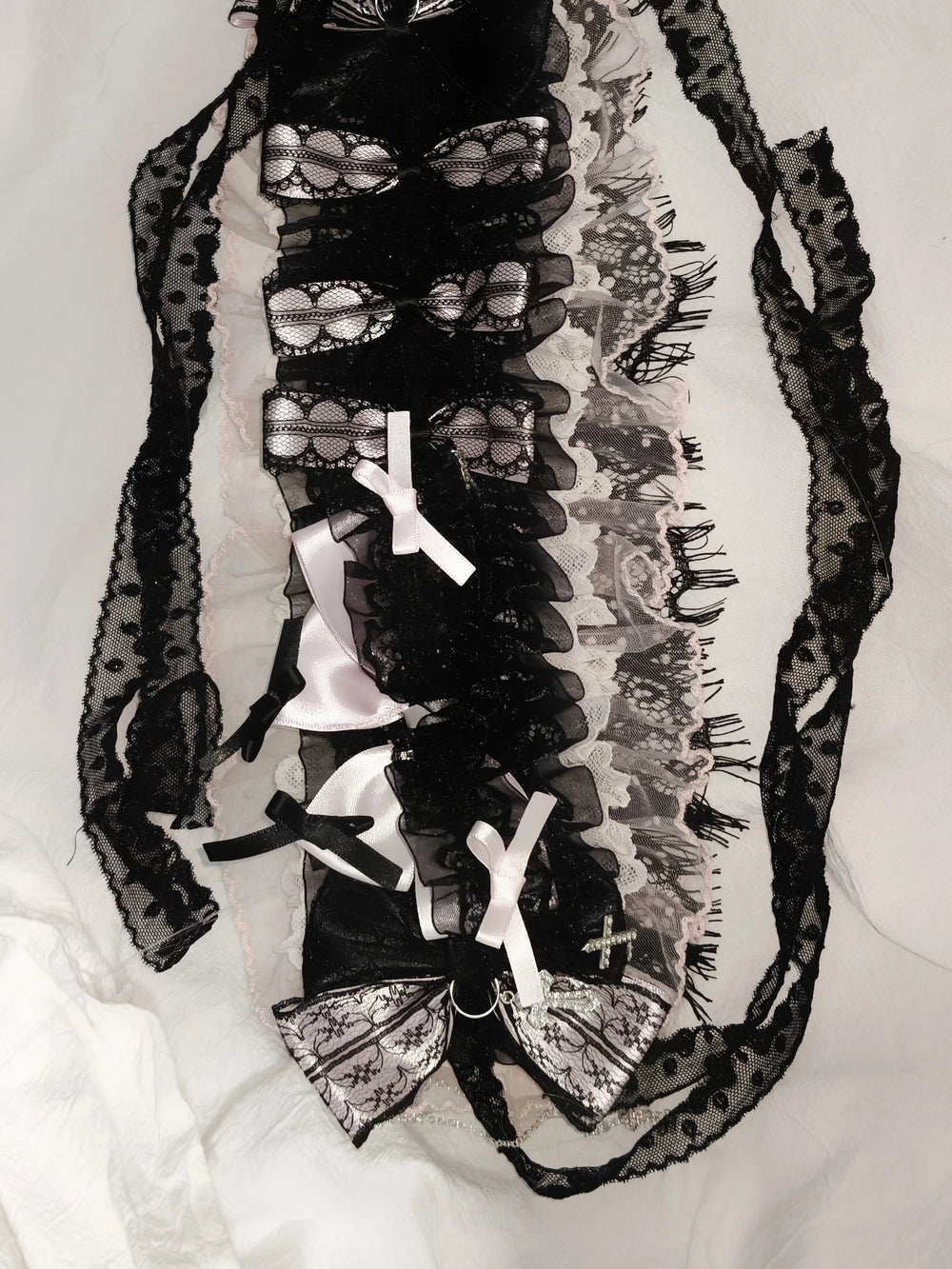 Heavily embellished black, pink and white lace hairband with layered bows and cross accents.