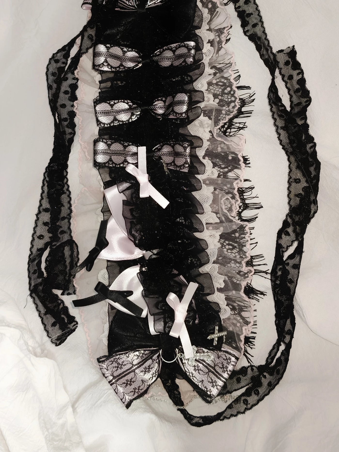 Heavily embellished black, pink and white lace hairband with layered bows and cross accents.