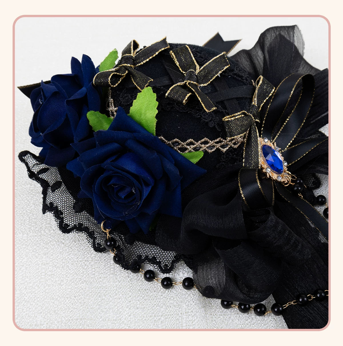 Dark Gothic mini hat hair accessory with gold trim, layered bows and trailing ribbons.
