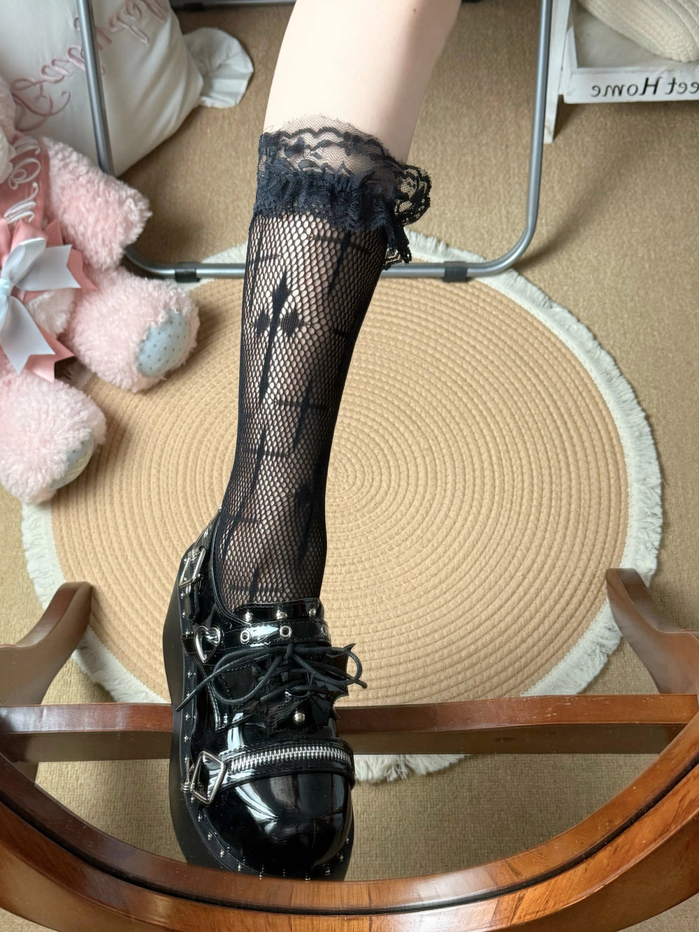 Black lace-trim calf socks with cross motifs worn with glossy platform shoes