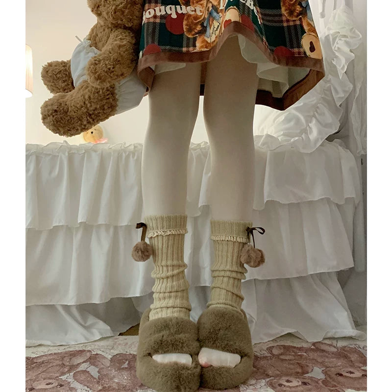 Coffee-color knit leg warmers with ribbon ties and pom-poms